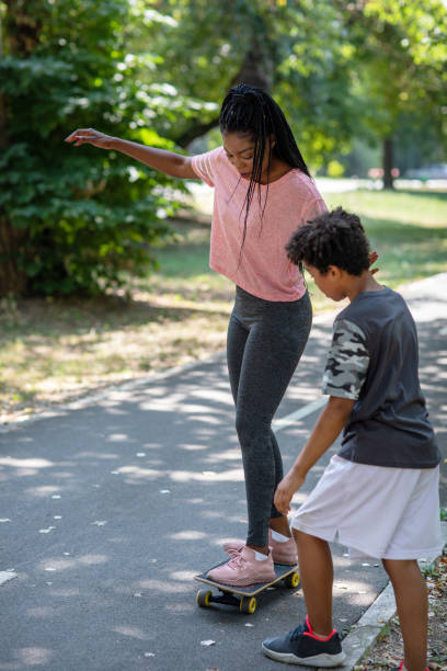 istock Cute 10 Years Boy Learning His Mother Skateboarding 1330326142