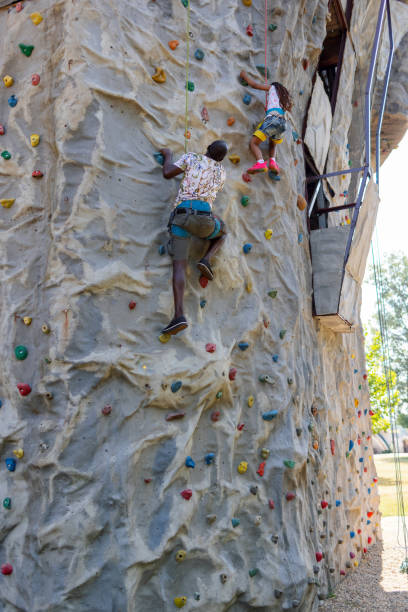 Father and daughter spending time together, they are enjoy wall climbing.