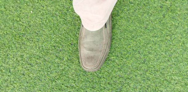 istock Foot Using Shoes on the Synthetic Green Grass Top View for Background 1330336684