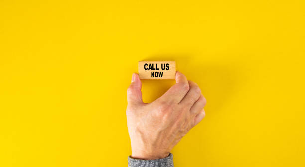 istock Hand holding a wooden block with text CALL US NOW. Service Support. 1330336899