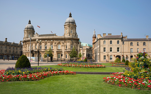 Hull, UK - July 22, 2021: Queens Gardens with grass and flowers and view of Maritime Museum and City Hall on July 22, 2021 in Hull, Yorkshire, UK.