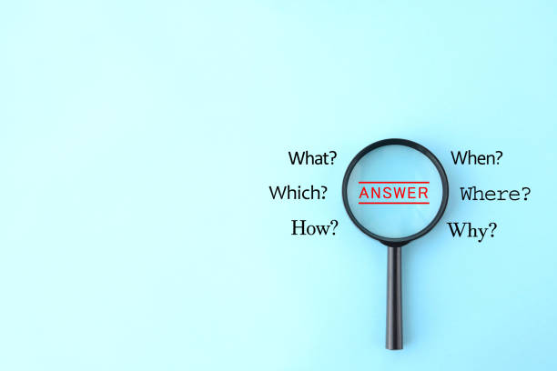 istock Magnifying glass and quesiton marks on light blue background 1330343590