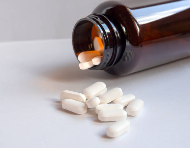 istock Medicinal pills are scattered from a brown bottle container close-up 1330345867