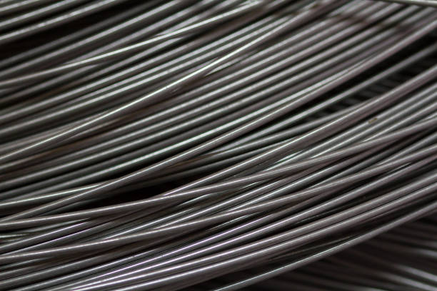 istock Stainless steel wire in production workshop or construction site. Close-up of wire rollers for spring production or concrete reinforcement. Metal texture. Industrial or construction concept. 1330345964
