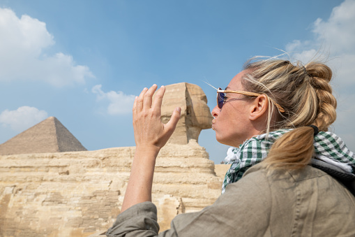 Side view of a female tourist enjoying a tour to the Pyramids of Giza in Egypt.
