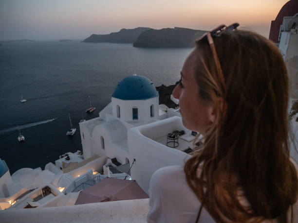 istock Woman contemplates Santorini from top, Greece 1330351246