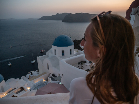 She looks at Oia town overlooking the ocean