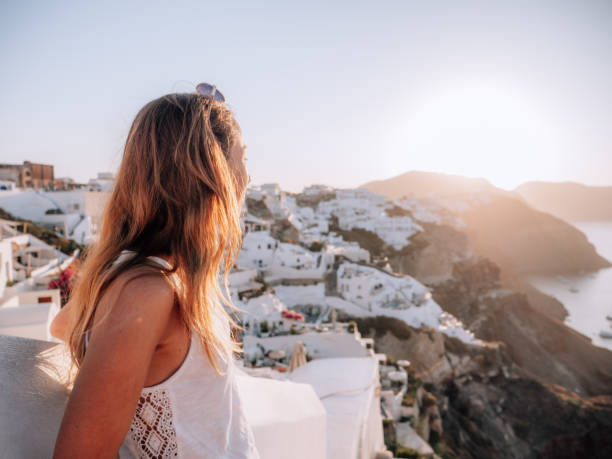 istock Woman contemplates Santorini from top, Greece 1330351296