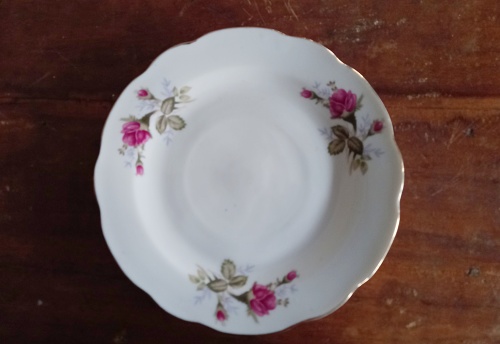 a classic small plate with a floral pattern with wood background