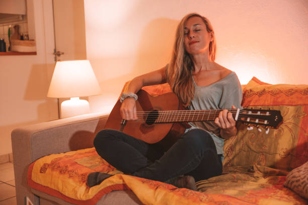 Woman plays guitar at home