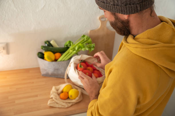 istock Man puts away vegetable groceries in the kitchen 1330353266