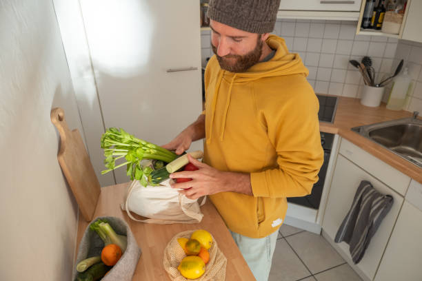istock Man puts away vegetable groceries in the kitchen 1330353267