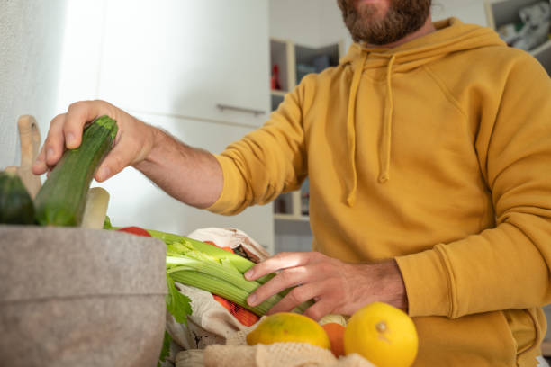 istock Man puts away vegetable groceries in the kitchen 1330353269