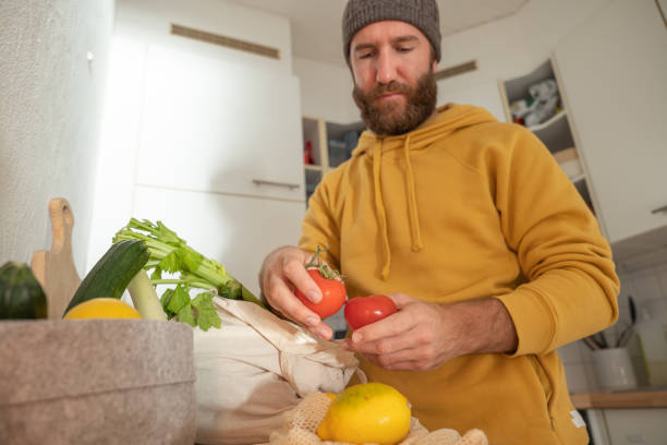 istock Man puts away vegetable groceries in the kitchen 1330353273