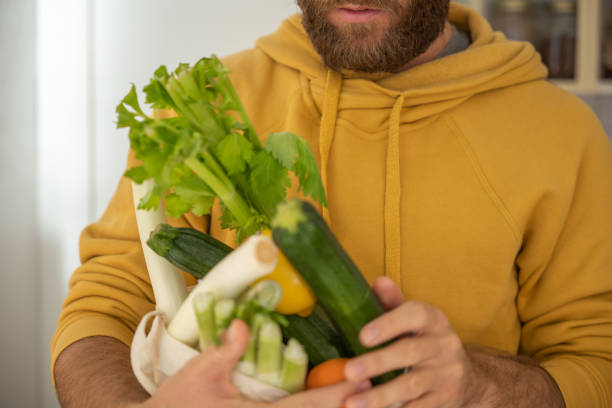 istock Man puts away vegetable groceries in the kitchen 1330353287