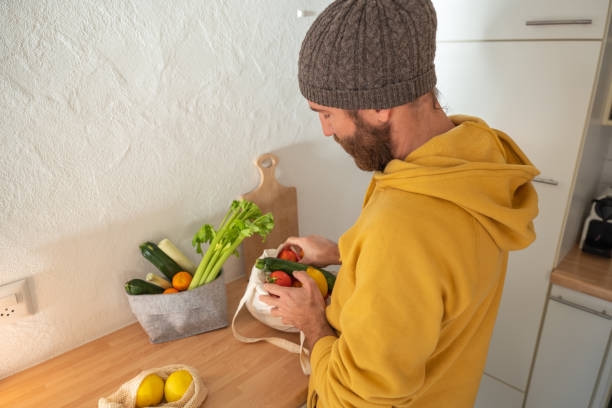 istock Man puts away vegetable groceries in the kitchen 1330353294