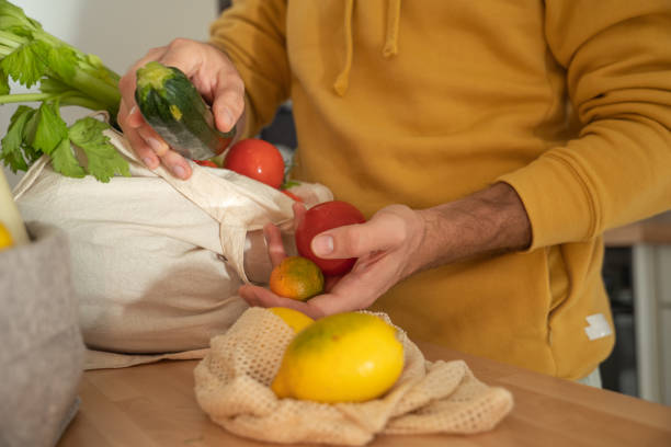 istock Man puts away vegetable groceries in the kitchen 1330353304