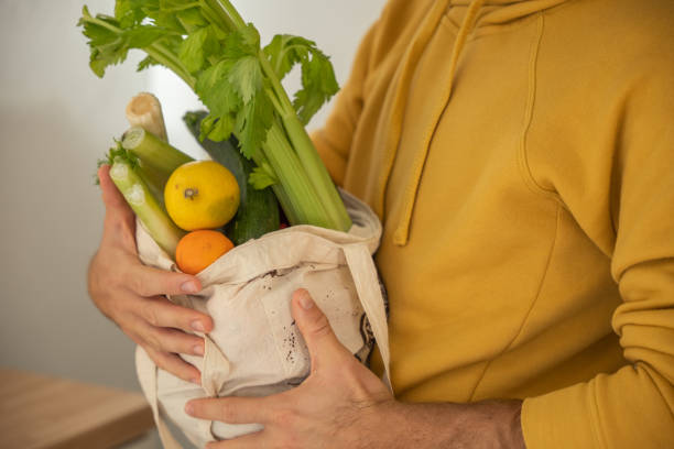 istock Man puts away vegetable groceries in the kitchen 1330353306