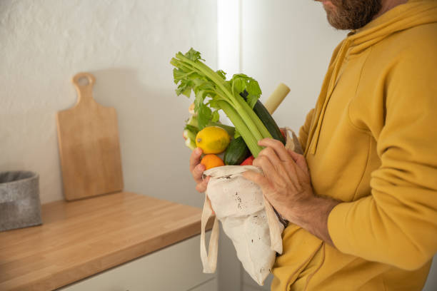 istock Man puts away vegetable groceries in the kitchen 1330353313