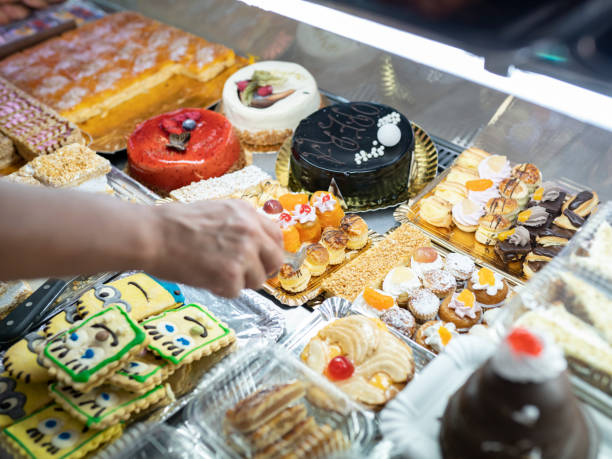 istock woman's hand taking cake in a pastry shop 1330354684