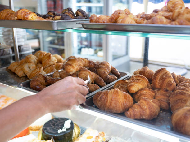 istock baker woman hand holding croissant 1330354688
