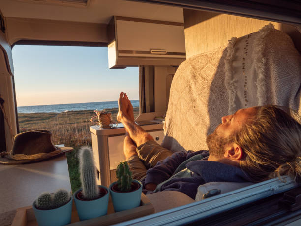 istock Man lying in a van looking at ocean 1330354826