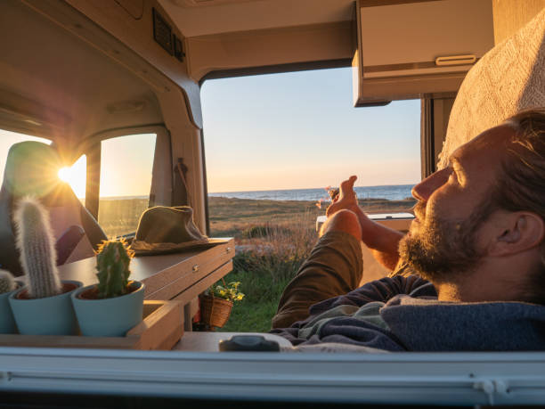 istock Man lying in a van looking at ocean 1330354835