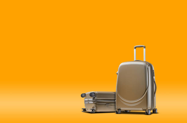 istock Two gray suitcases are standing against an orange background. A realistic shadow is drawn in under them. Collage. Copy space, close-up 1330355662