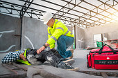 Accident at construction site. Physical injury at work of construction worker. First Aid Help a construction worker who accident at construction site.
