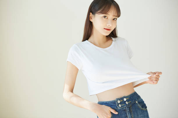 a young asian woman in a white t-shirt - torso women jeans abdomen imagens e fotografias de stock