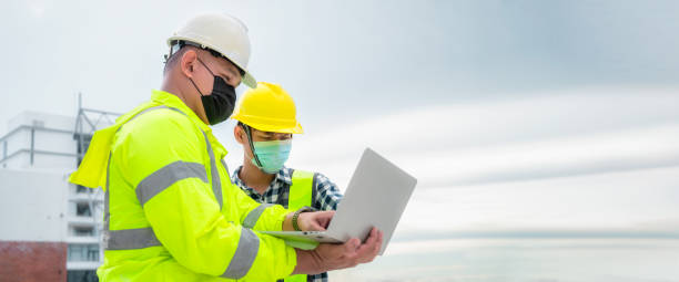 istock Banner : Civil engineer wearing mask inspect construction site structure and plans in laptop. 1330359305