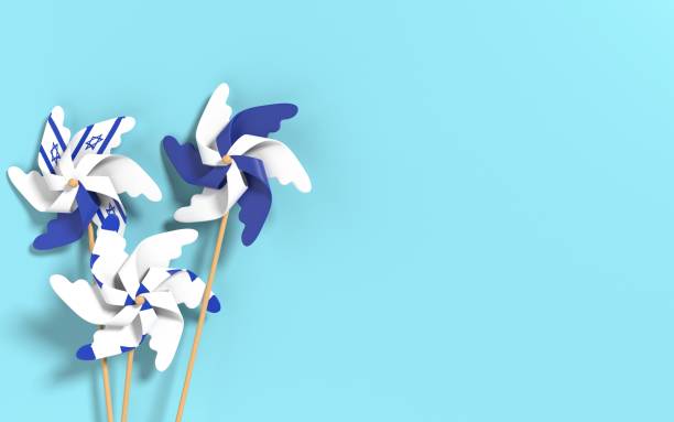 istock Israeli Flag on White Paper Flower Windmills on Blue Background 1330364507