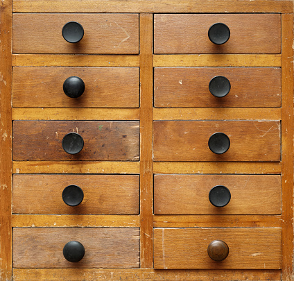 Backgrounds and textures: very old wooden cabinet with drawers with black handles, front view