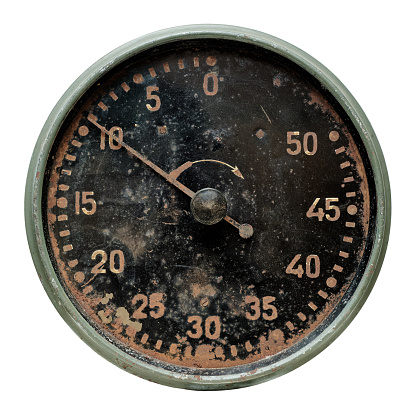 Isolated objects: faceplate of very old mechanical timer, rusty and stained, on white background