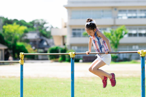 Girl playing horizontal bar in the schoolyard