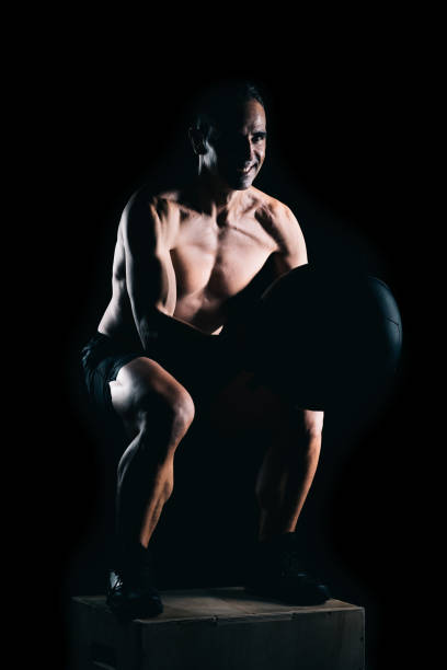 istock Strong man doing squats with a medicinal ball i 1330369781