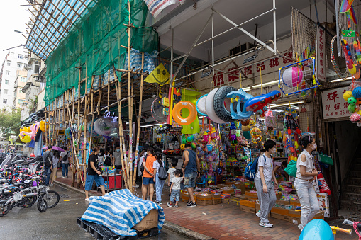 Hong Kong - July 24, 2021 : People at the Fuk Wing Street (Toy Street) in Sham Shui Po, Kowloon, Hong Kong. Also known as Toy Street, this spot is a go-to for those looking for children’s toys, affordable stationery, knock-offs and party accessories.