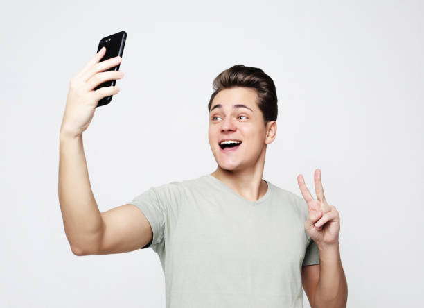 istock Photo of handsome man smiling on camera taking selfie 1330371881