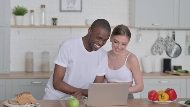 istock Woman and African Man Talking on Video Call in Kitchen 1330373918