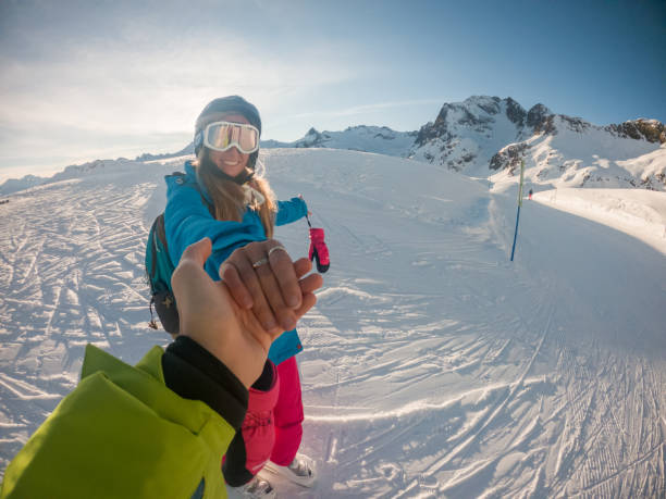 istock Couple holding hands on ski slope 1330383152