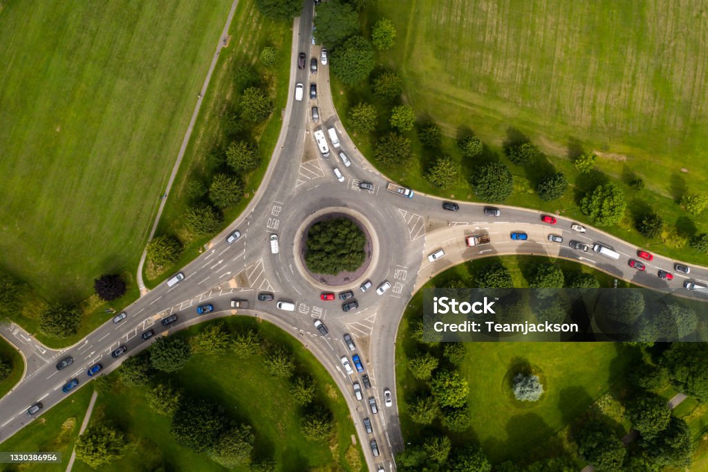 Aerial view of busy roundabout junction at rush hour Aerial view of a busy countryside road roundabout at rush hour with traffic queueing UK Stock Photo