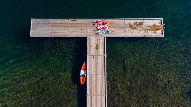 istock Family lounging on a lakeside dock 1330387105
