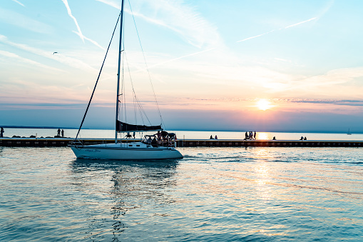 A yacht is driving on Lake Ontario at dusk, St. Catharines, Ontario, Canada.