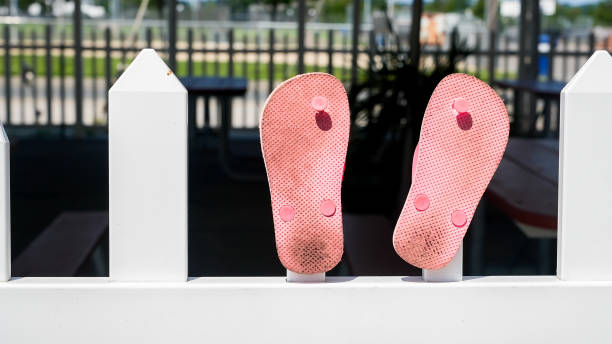 istock Pink flip flops outside on white fence 1330389083