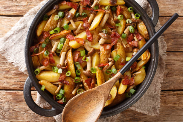 istock Rustic style fried potatoes with onions, mushrooms and bacon close-up in a pan. horizontal top view 1330390673