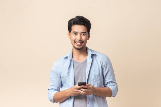 istock Portrait young Asian man handsome smile using smartphone in studio. 1330392828