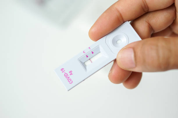 istock Negative self-test result for COVID-19, man's right hand holding covid19 rapid antigen test kit and left empty space against blurred white background 1330395420