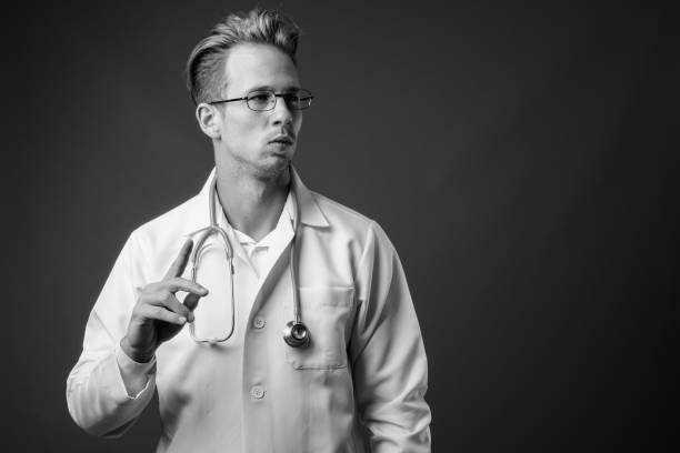 istock Young handsome man doctor with eyeglasses in black and white 1330396642