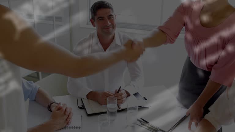 Data processing against against mid section of businessman and businesswoman shaking hands at office