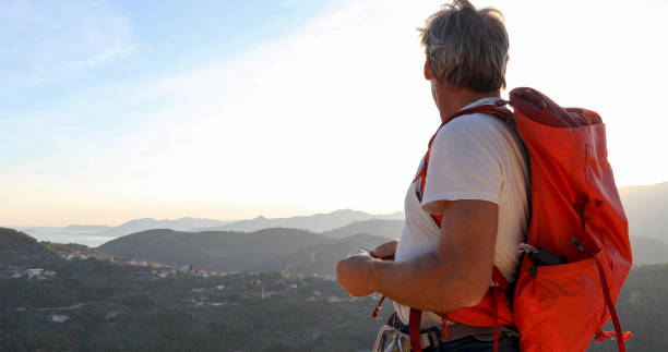 istock Mountaineer relaxes on mountain ridge at sunrise 1330399225